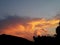 Fire red and gold yellow sunset over mountain and tropical silhouettes