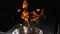 Fire rising up out of stainless frying pan on dark background. Cooking flambe dish. Close-up of Chef Preparing Flambe