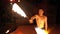 Fire Show Performance on Stage. Young Man Dancing with Fiery Fans on a Night Show. Slow Motion