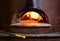 Fire stone stove oven for preparing traditional italian pizza. Fire wood burning in oven.