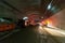 Fire trucks entering a large tunnel with red lights for rescue