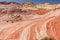 Fire wave with swirly layers of deposited sandstone during wonderful sunny day with blue sky, in Valley of Fire State Park