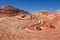 Fire wave with swirly layers of deposited sandstone during wonderful sunny day with blue sky, in Valley of Fire State Park