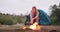 Fire, woman and camping wood with flames for heating hands and calm in nature with a tent. Adventure, field and rocks in