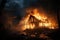 Fire in wooden house or barn at night, burning single family home. Hut in flames and smoke. Concept of damage, disaster, insurance