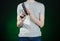 Firearms and murderer topic: man in a gray t-shirt holding a gun on a dark green background isolated in studio