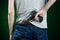 Firearms and murderer topic: man in a gray t-shirt holding a gun on a dark green background in studio