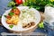 Fired cordon bleu chicken served with rice and parsley on plate.Chicken fillet baked in cheese with rice and vegetables.