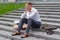 A fired office worker sits on the steps. The man does not know what to do next.