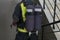 A firefighter with a breathing apparatus, in the form of two cylinders on his back, goes down the smoke-free stairs to check the