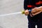 Firefighter demonstrating how to use a water hose to children during a display, helping a child hold the hose tap