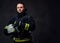 Firefighter dressed in uniform holds safety helmet.