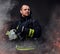 A firefighter dressed in a uniform in a studio.