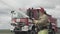 Firefighter holding water hose near truck with equipment