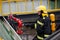 Firefighter holds a fire suppression system hydrant on a hospital helipad during a cold cloudy winter day