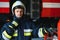 Firefighter portrait on duty. Photo fireman with gas mask and helmet near fire engine.