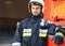 Firefighter portrait on duty. Photo fireman with gas mask and helmet near fire engine.