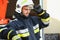 Firefighter portrait on duty. Photo fireman with gas mask and helmet near fire engine.