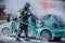 Firefighter pouring foam on a burned car