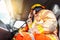 A firefighter in protective clothing and a helmet sits in a cargo rescue vehicle and talks on the radio