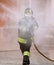 Firefighter with a protective helmet uses a foaming agent
