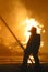 Firefighter in silhouette against flames