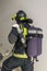 Firefighter in special clothes holds a sleeve line, back view