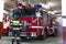 A firefighter in special clothes stands in front of a fire truck