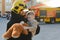 A firefighter take a little child boy to save him. Fire engine car on background