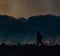 A firefighter walking in burning fields