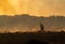 A firefighter walking in burning fields