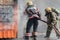 Firefighters extinguishing fire from fire hose, using firefighting water-foam barrel with air-mechanical foam