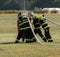 Firefighters filling water bucket under helicopter