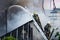 Firefighters fills the fire with water on roof of the hose standing on the stairs against a background of thick white smoke.. It\'