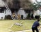 Firefighters prepare to enter a burning house