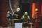 Firefighters put out large massive fire blaze, group of fire men in uniform during fire fighting operation in the city streets,