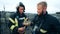 Firefighters are smiling while looking at a bird's nest