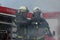 Firefighters using water fog type fire extinguisher to fighting with the fire flame to control fire not to spreading out