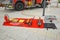 Firefighting tools like extinguishing blanket, hydraulic rescue cutter or fire extinguisher from  fire truck on display on red bla