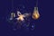 A firefly butterfly flies out of a crashed incandescent lamp. Fairytale picture. Sparks and smoke. Dark blue background