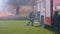 Fireman with Fire Hose in Forest near a Fire Truck Prepares to Extinguish Fire