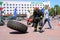 A fireman in a fireproof suit runs and turns a large rubber wheel in a fire fighting competition, Belarus, Minsk, 08.08.2018