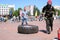 A fireman in a fireproof suit runs and turns a large rubber wheel in a fire fighting competition, Belarus, Minsk, 08.08.2018