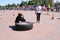 A fireman in a fireproof suit runs and turns a large rubber wheel in a fire fighting competition, Belarus, Minsk, 08.08.2018