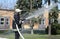 Fireman in protective costume watering plant territory with syringe - Rescue team training of firefighting