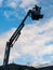 A fireman`s crane in action, silhouette against a cloudy sky.