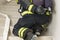 A fireman`s hand opens a cylinder with compressed air for breathing in a smoky room