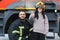 A fireman shows his work to his young son. A boy in a firefighter& x27;s helmet