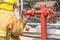 Fireman in yellow fire fighter uniform during connect firehose tube in to fire hydrant