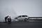 Firemen extinguish a burning car on a highway